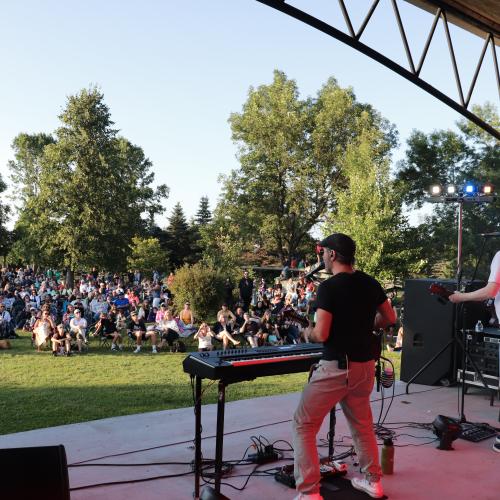 Close up of band playing overlooking crowd outdoors
