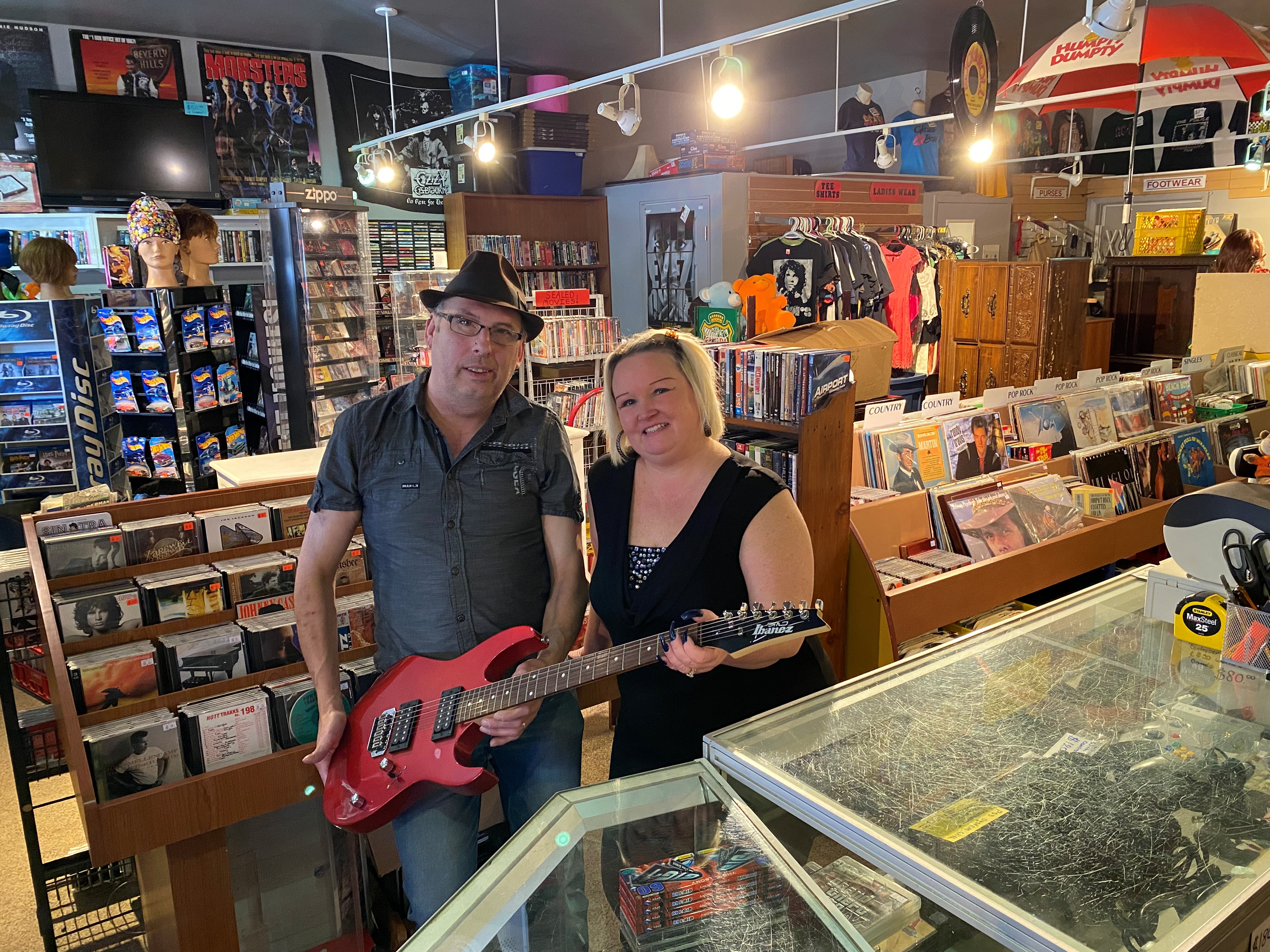 Matt and his wife inside the shop holding a guitar