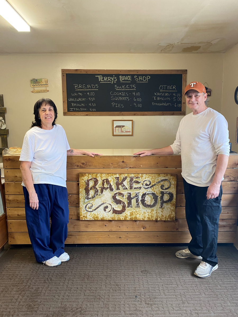 man and woman stand at counter inside bake shop