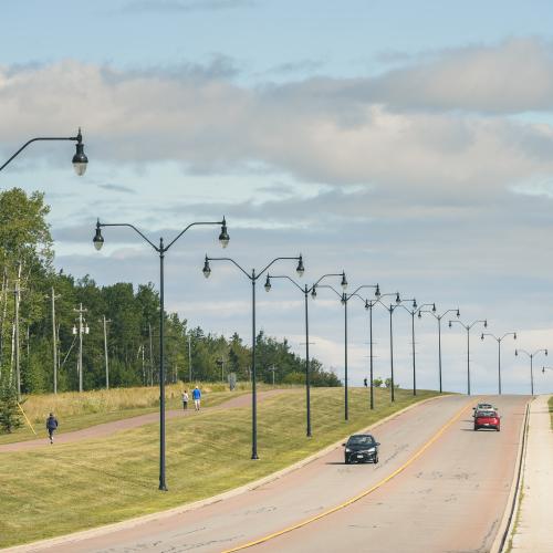 View of walking path next to a street with a series of streetlights