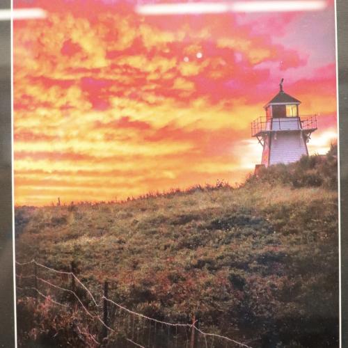 Photograph of a fiery sky and a lighthouse landscape.
