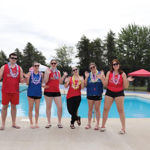 A team of lifeguard wearing flower necklaces at outdoor pool