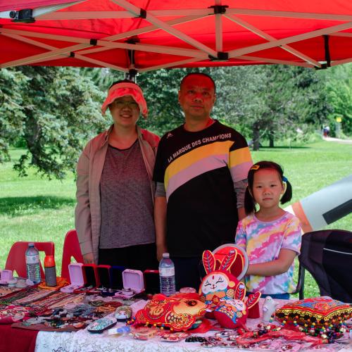 A family selling items at an outdoor table 