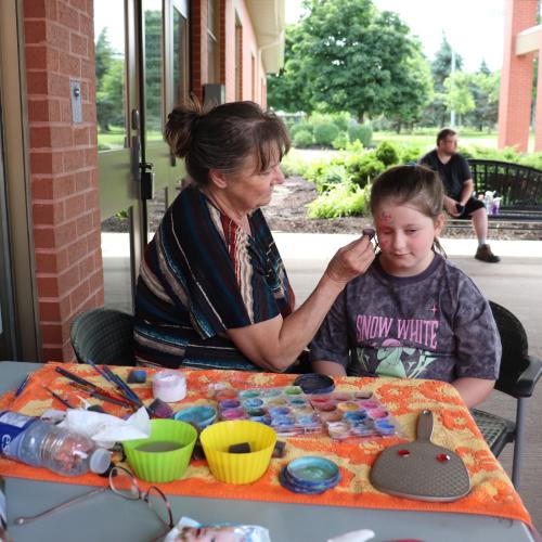 A young girl getting her face painted