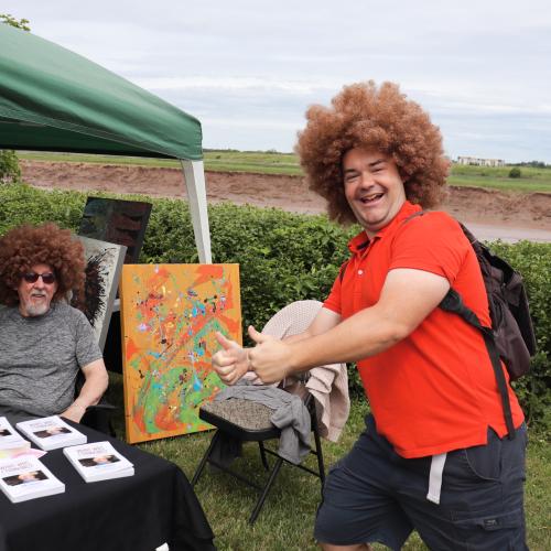 Two men in wigs smiling outside