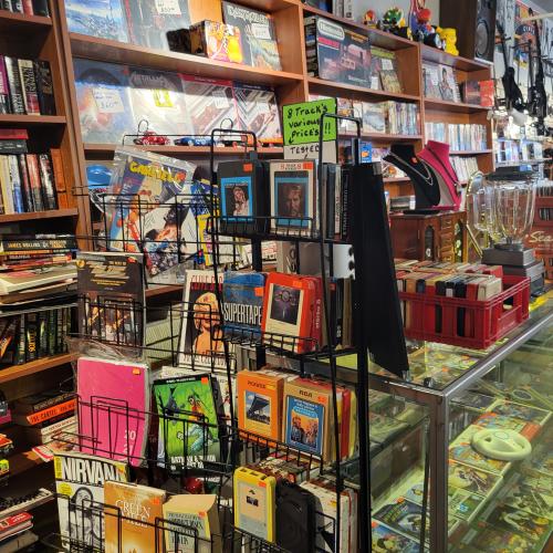 Various books, video games and records placed in cases or on shelves.