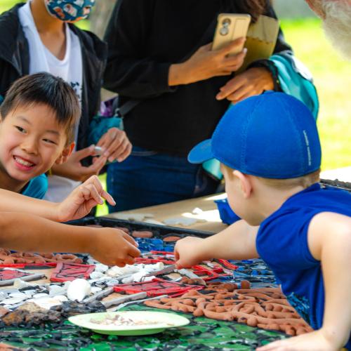 Children working together on a mosaic outside 