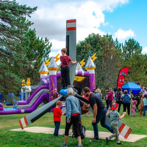 A group of people in a park with bouncy castles 
