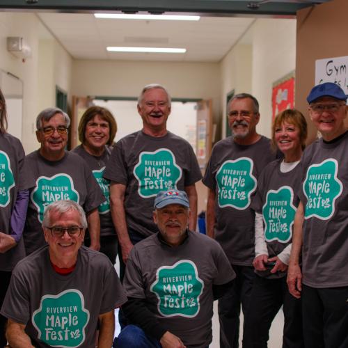 A group of people wearing matching maple fest shirts
