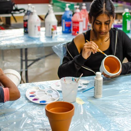 Youth painting flower pots 