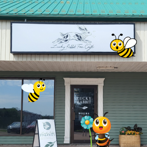 Lucky Rabbit Fine Craft store front surrounded by cute bee graphics.