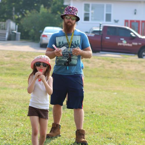 A girl and her dad eating freezies
