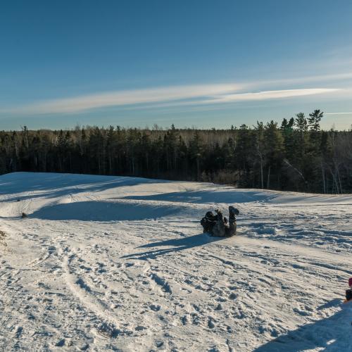 A family at the stop of a sliding hill in the winter