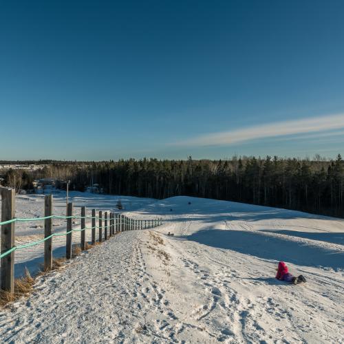 A child laying on a slide going down a steep hill