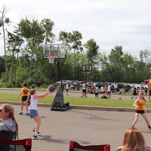 A team of girls playing basketball outside in a tournament
