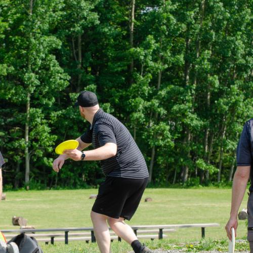 A man throwing a yellow frisbee
