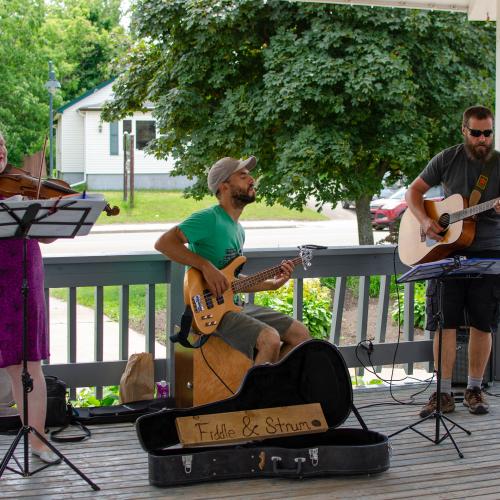 Three musicians playing in a bandstand outside