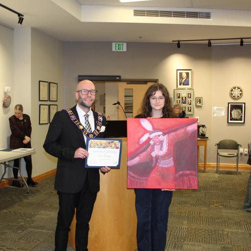 Artist holding artwork with mayor, smiling