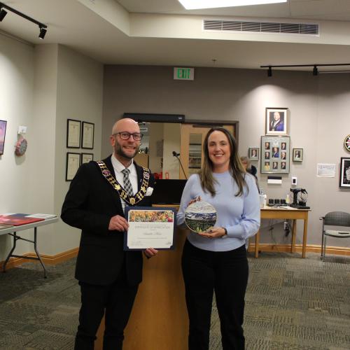 Artist holding artwork with mayor, smiling