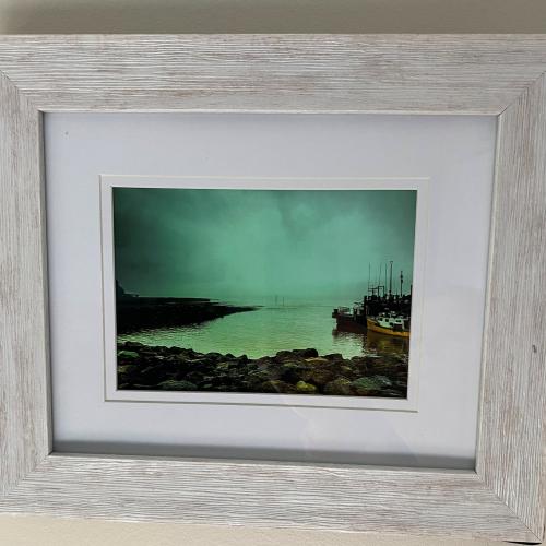 A photo of the sea, a fishing boat, and the rocky shore 
