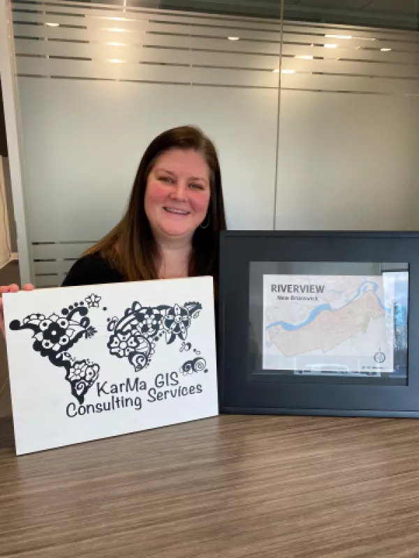 GIS Consultant standing with map and sign