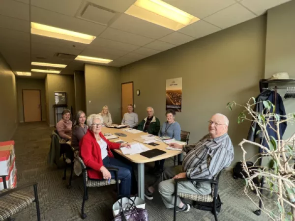 Seniors sitting around a table in a meeting room