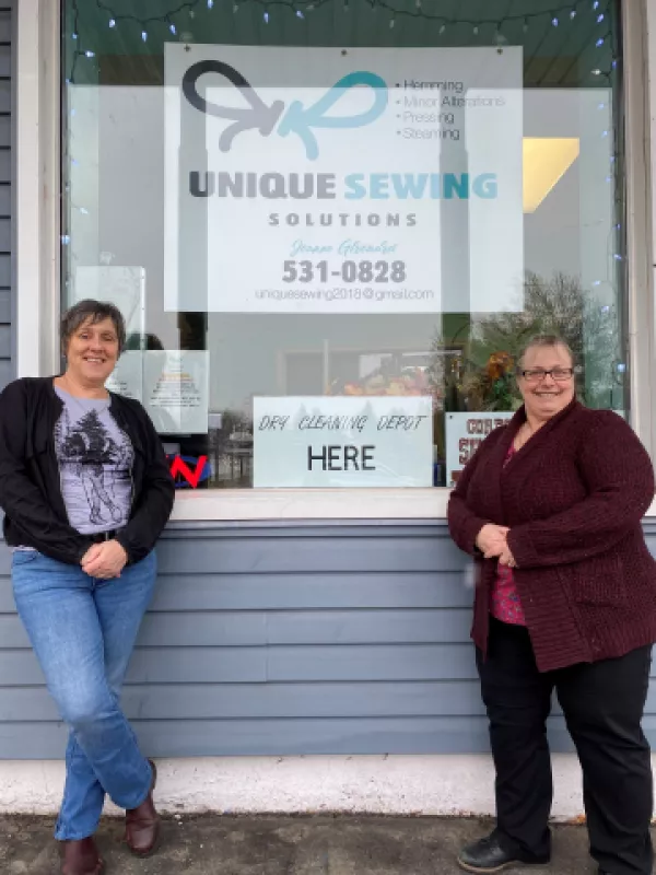 Two women standing outside business