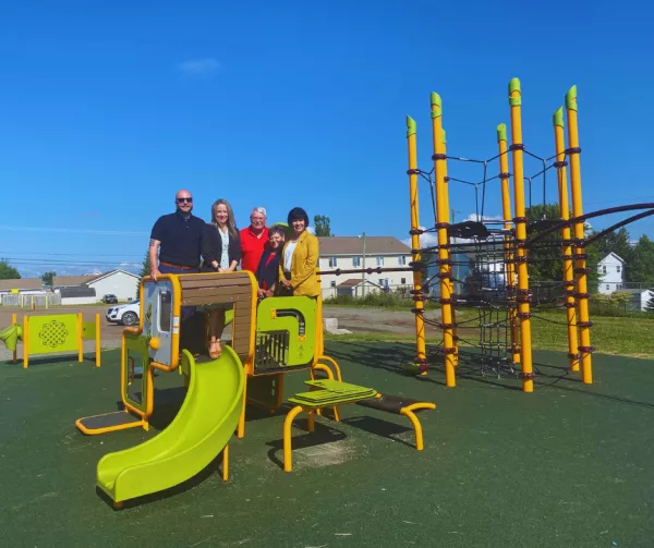 Members of Council stand on play equipment with Minister Ginette Petitpas Taylot