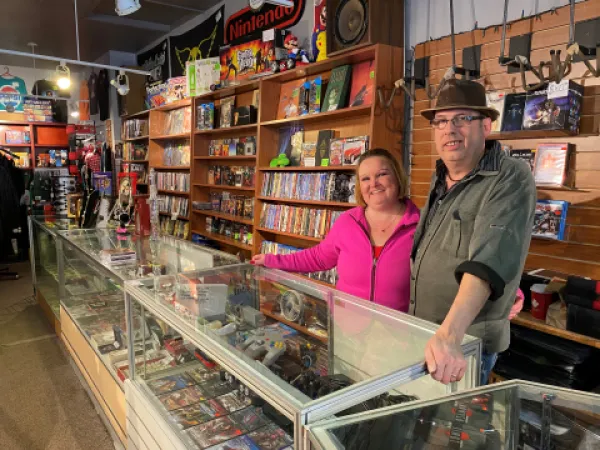 A couple standing behind display case in a buy, sell, trade shop