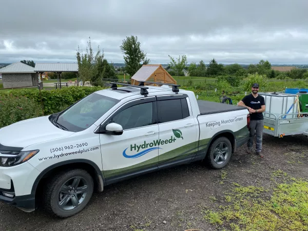 Hydro Weed+ owner standing next to branded truck
