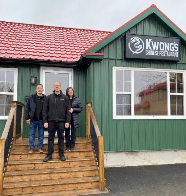 Restaurant owners standing on steps outside of building