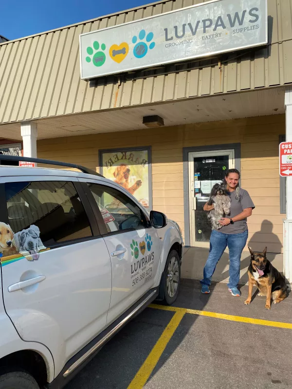 Luv Paws owner Vicky outside her storefront with two dogs