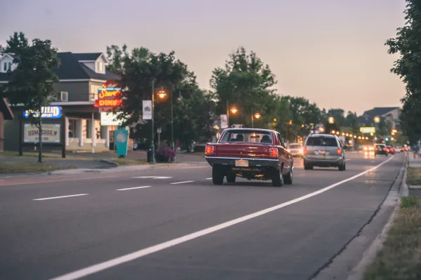 two cars drive down coverdale road past businesses