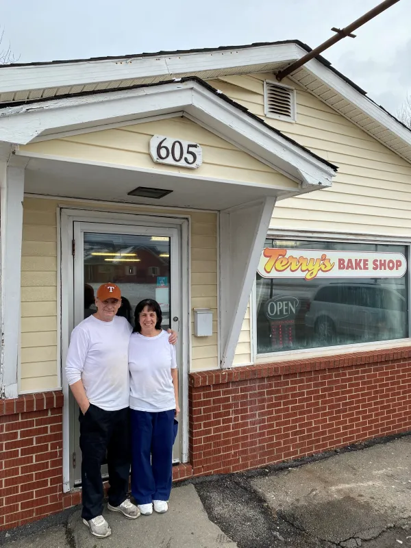 man and woman stand outside bake shop