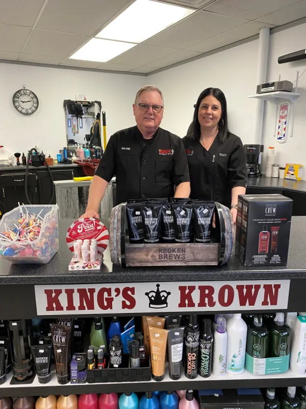 Owners stand inside barbershop