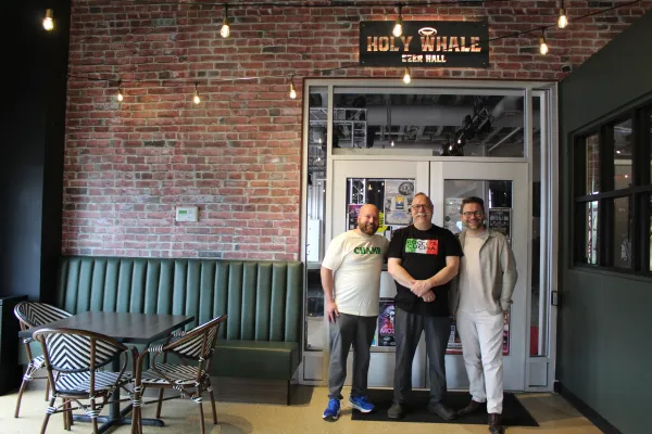 Three business owners smiling and standing together