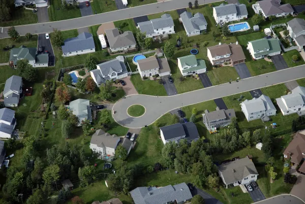 Aerial view of a residential neighbourhood with houses, streets, and trees