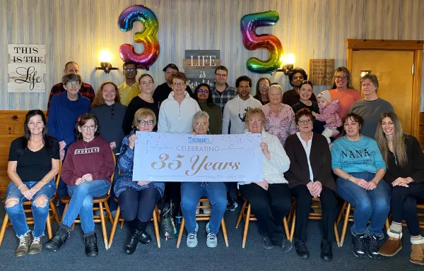 The Homestead staff pictured with a 35th Anniversary banner and balloons. 