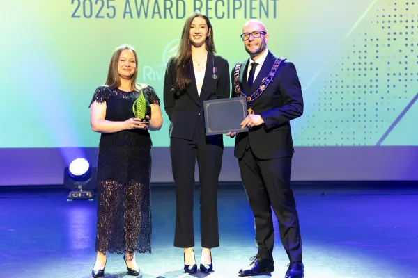 Mayor and award presenter present an award to the recipient.
