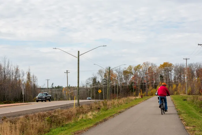 A cyclist biking on a paved pathway alongside gunningsville blvd.