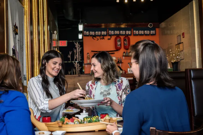 4 women at a table enjoying a meal at a local restaurant.