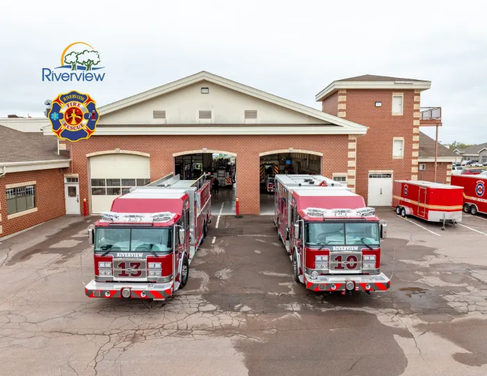 Two new firetrucks in front of bay doors of fire station