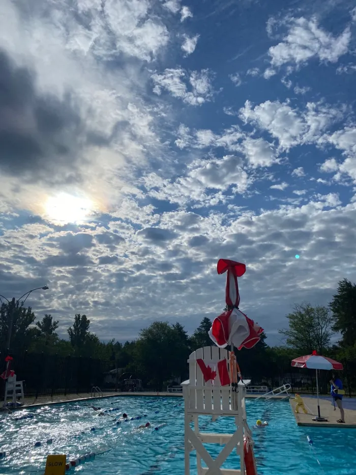 An outdoor pool with the sun shining on it
