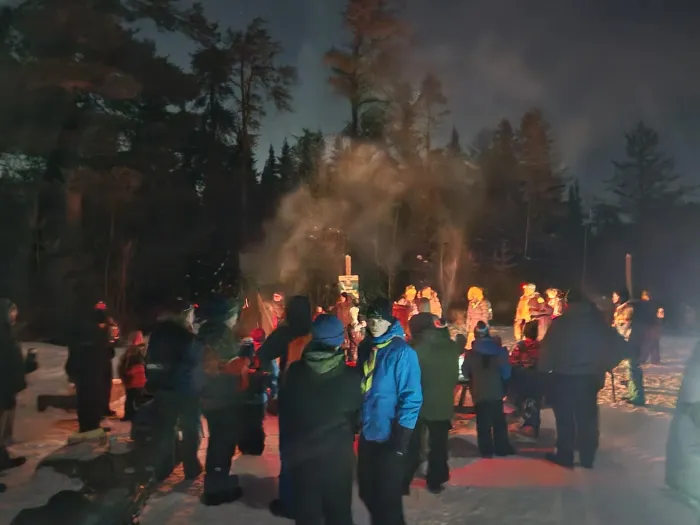 People gathered around a campfire in Mill Creek Nature Park.