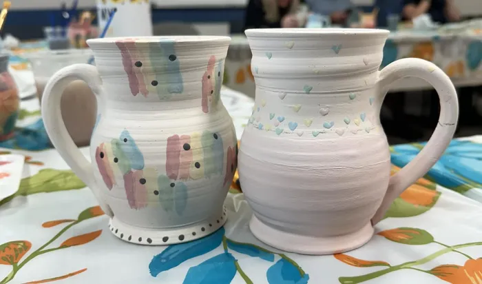 2 painted pottery mugs side by side