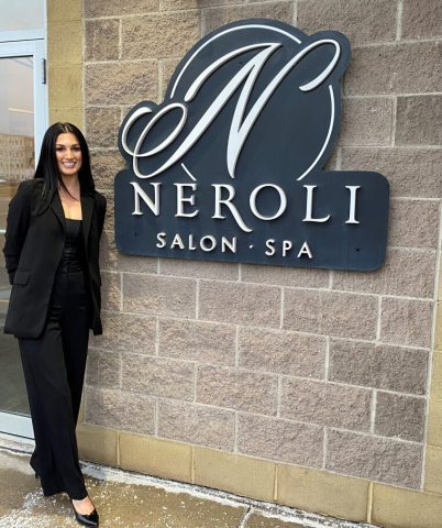 Spa owner standing outside her business smiling