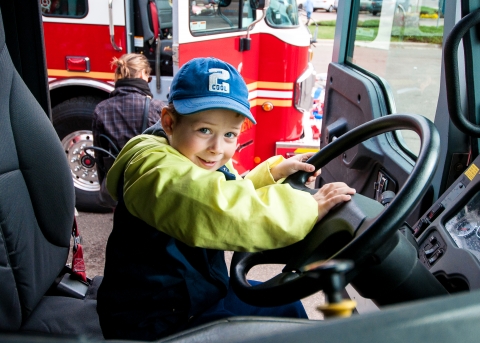 Boy behind wheel of fire truck