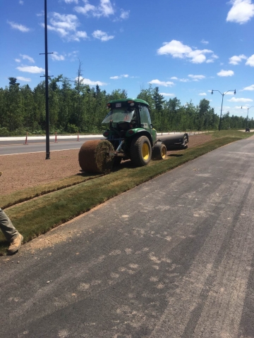 Turf being laid on the side of the road