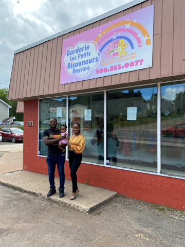 Business owners standing outside building with child