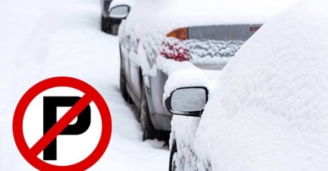Vehicles parked on snowy road. A No Parking symbol is placed over the photo. 